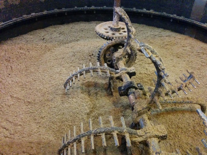 The open mash tun at Bruichladdich with rakes to move the mash around.