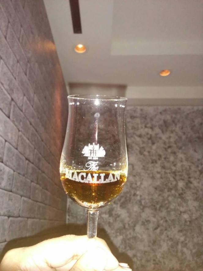 A glass of The Macallan Rare Cask, presented in a sturdy Macallan-branded copita glass.